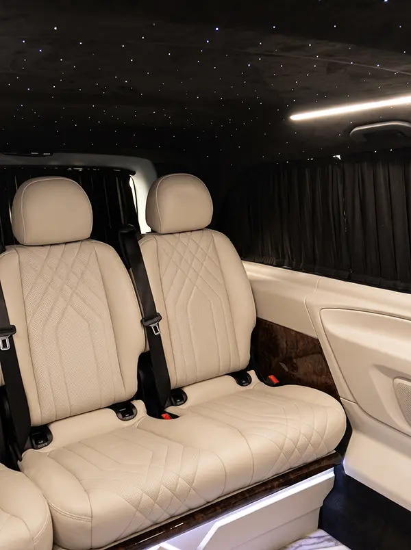 Custom luxury leather interior with starlight ceiling in Riviera Black VIP Mercedes transfer van